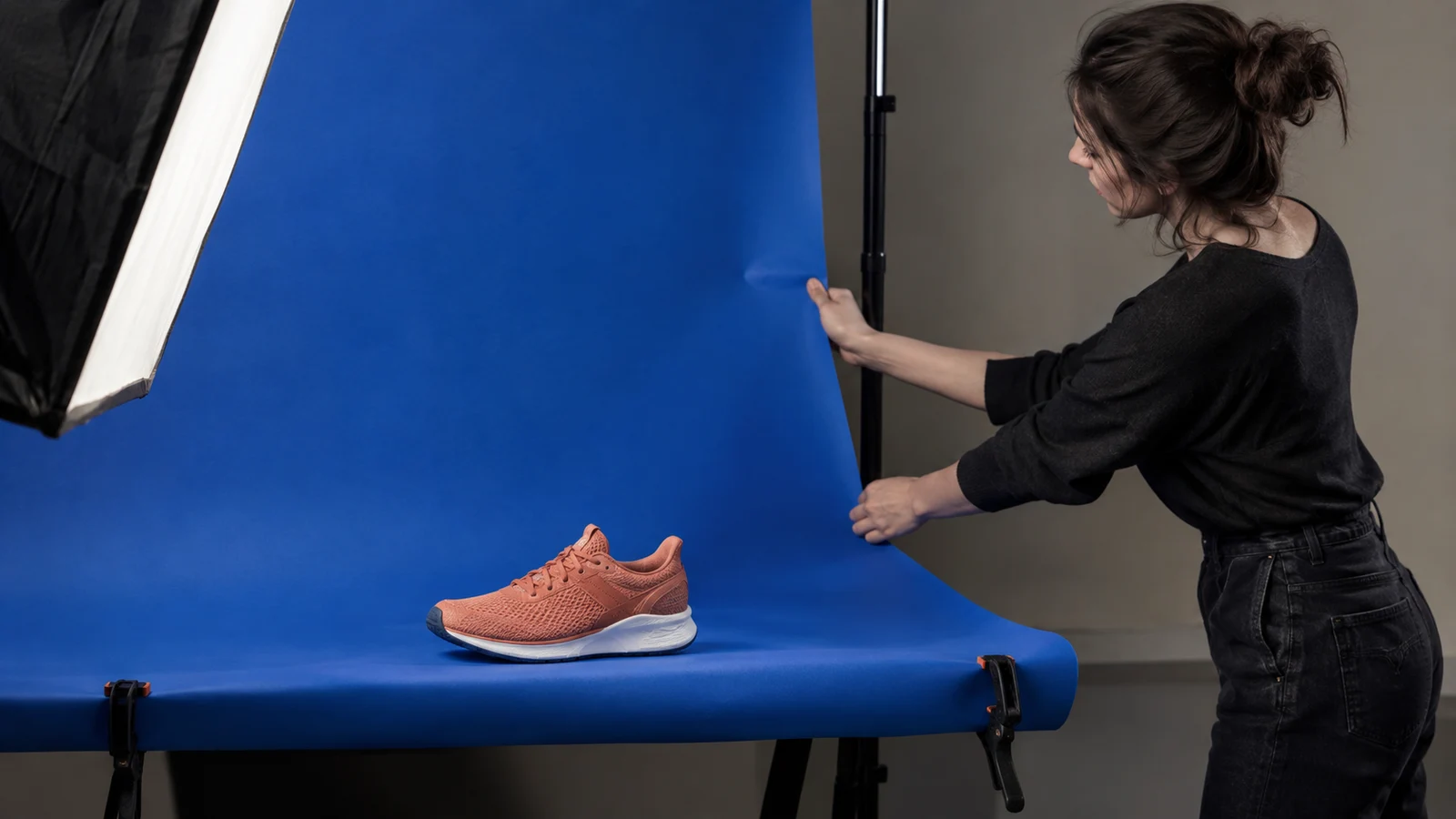 Una profesional prepara el fondo de una sesión de fotografía de producto.