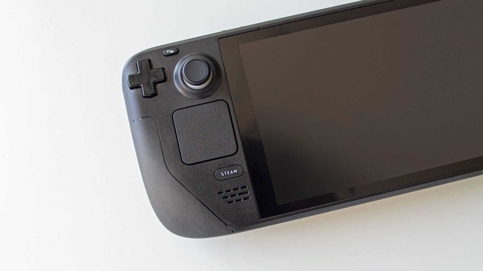 Detalle de los controles y la pantalla apagada de una Steam Deck sobre fondo claro.