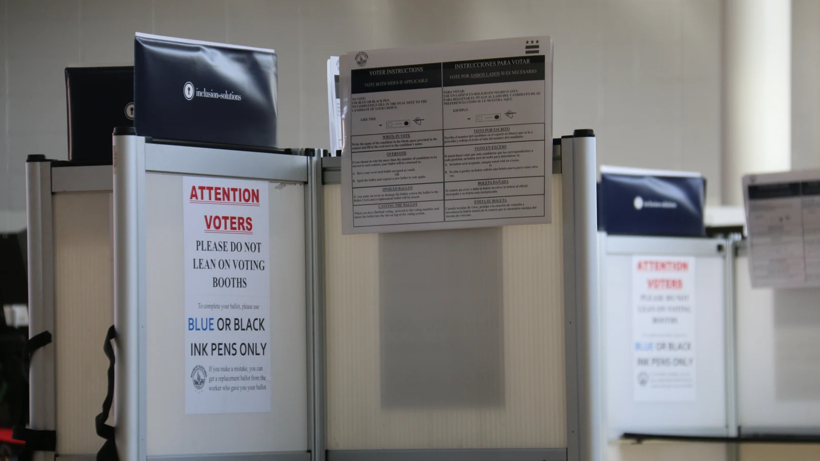 Cabinas de votación vacías con carteles de instrucciones en un colegio electoral de Washington DC.