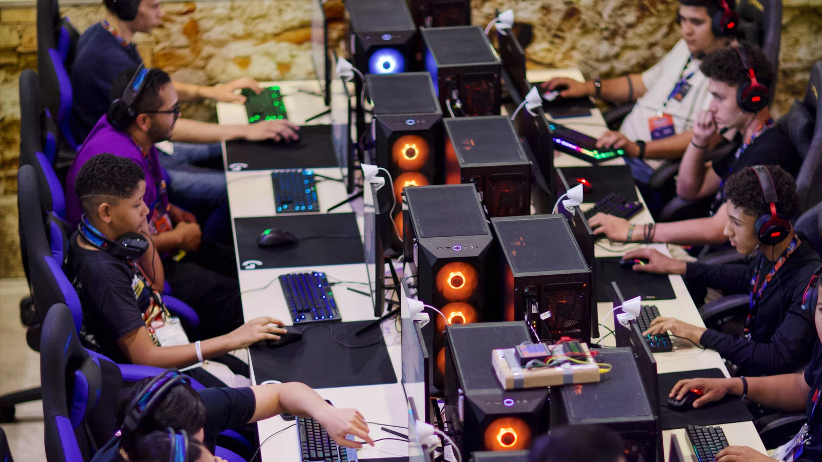 Jugadores con auriculares y ordenadores durante una competición de deportes electrónicos.