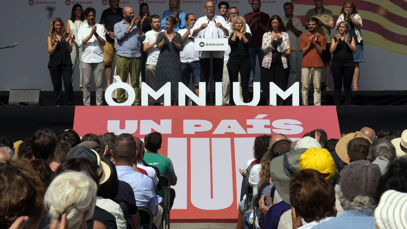Participantes en un acto de Òmnium Cultural sobre un escenario.
