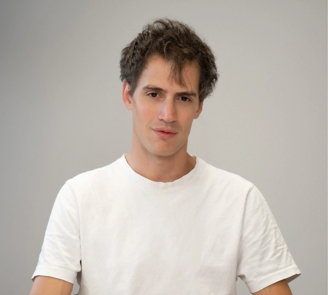 Retrato de Arthur Mensch con camiseta blanca.
