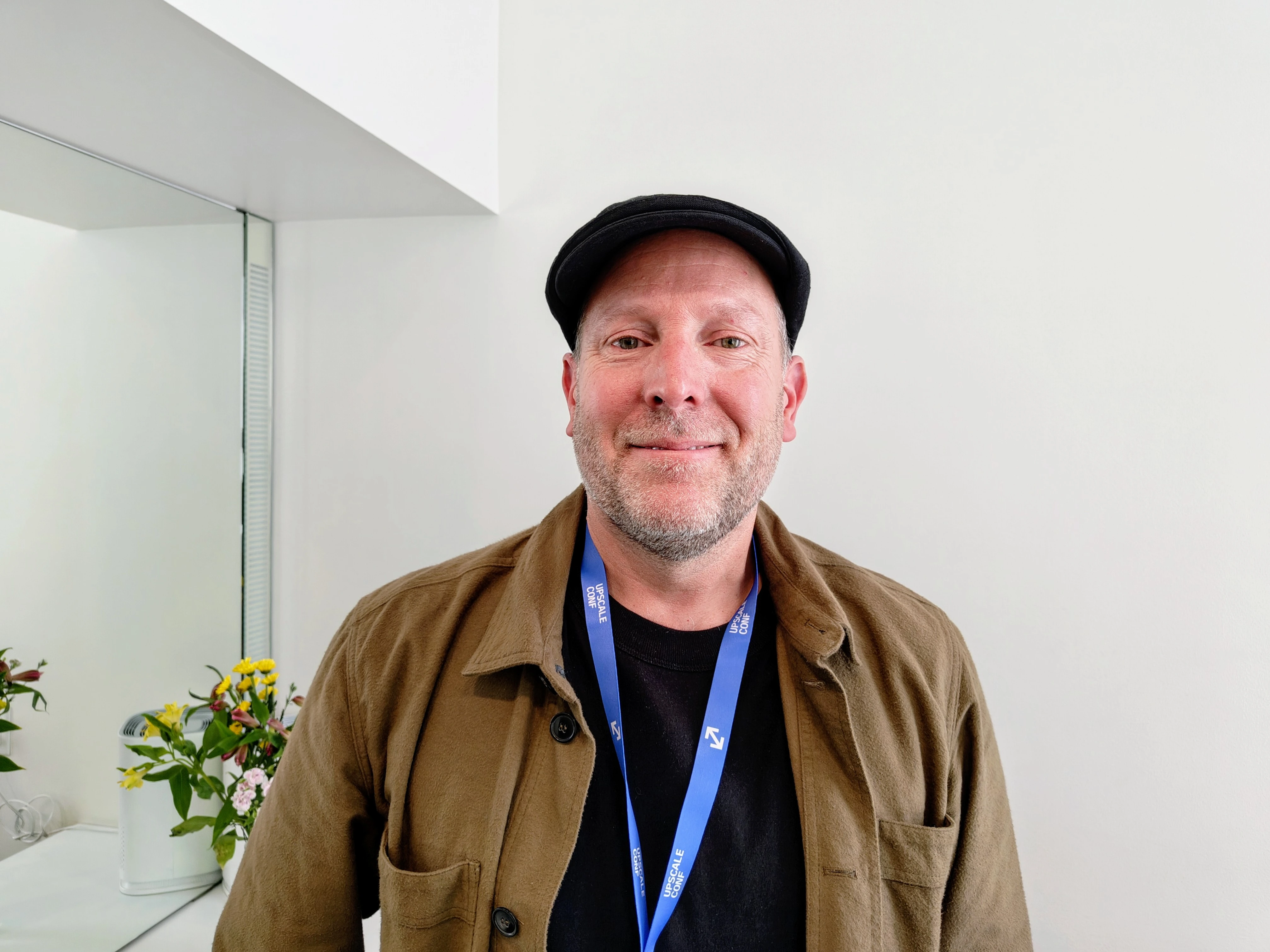 Chad Nelson posa con gorra negra, chaqueta marrón y acreditación azul.