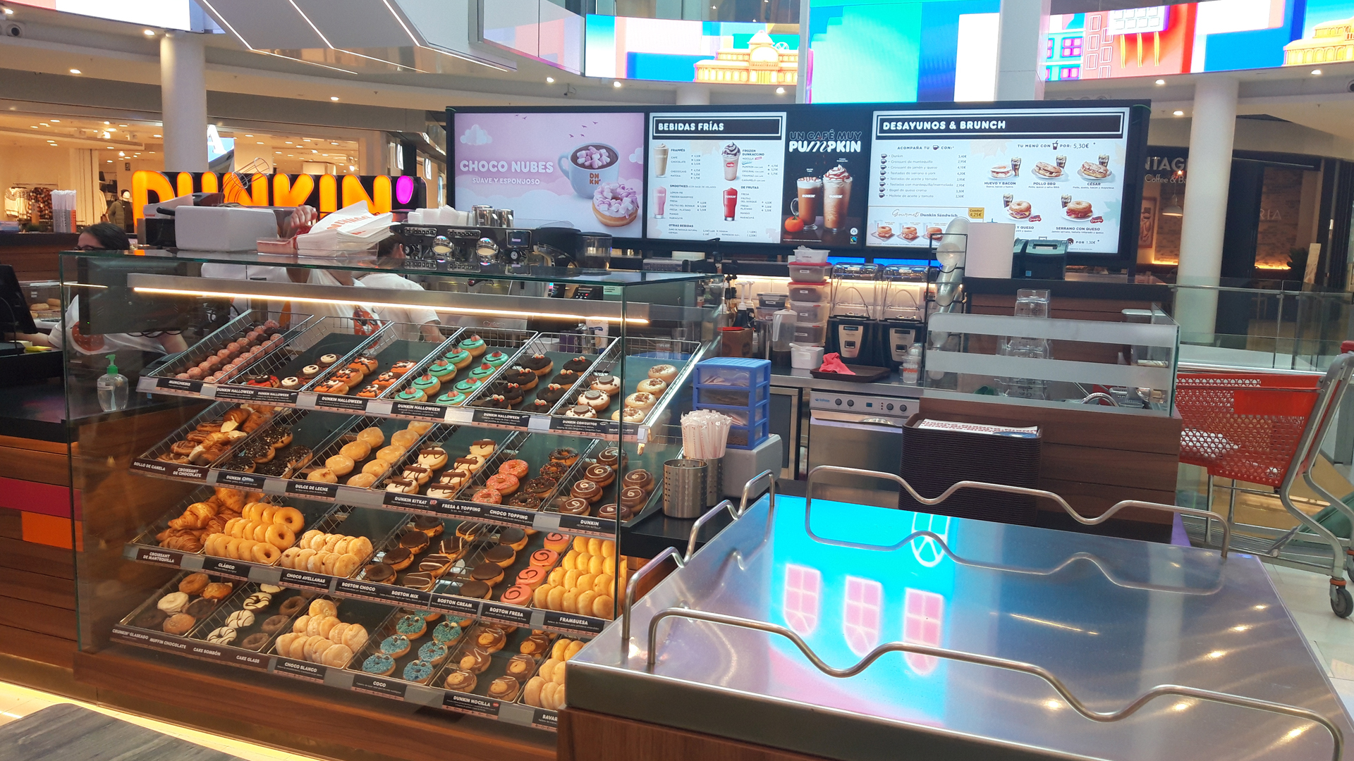 Mostrador de Dunkin con vitrinas de producto y una persona atendiendo en el interior de Plenilunio.