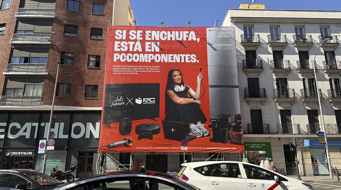 Valla urbana de PcComponentes con Juls Janeiro y el lema sobre el enchufe.