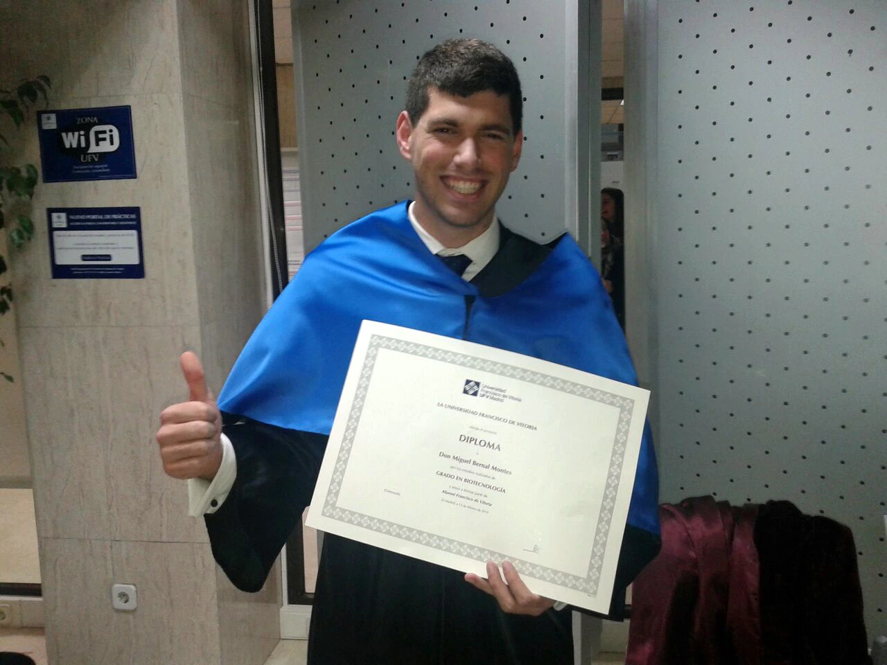 Miguel Bernal, Mikecrack, posa con beca azul y su diploma de graduación.